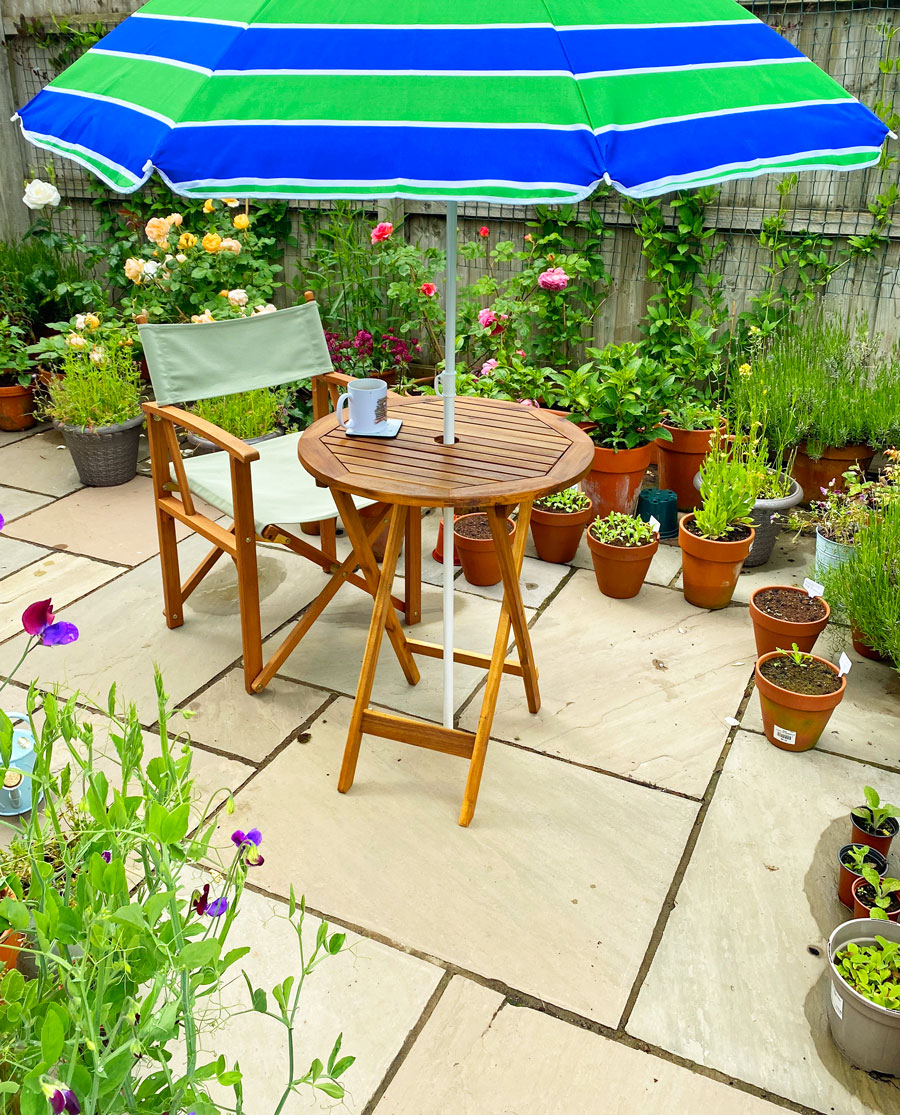 bistro set on patio surrounded by potted plants